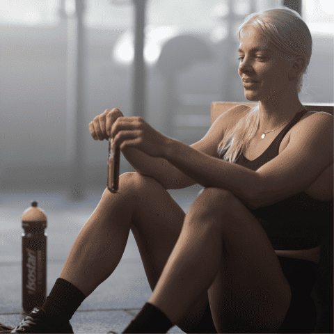 Une femme assise ouvre une barre Isostar